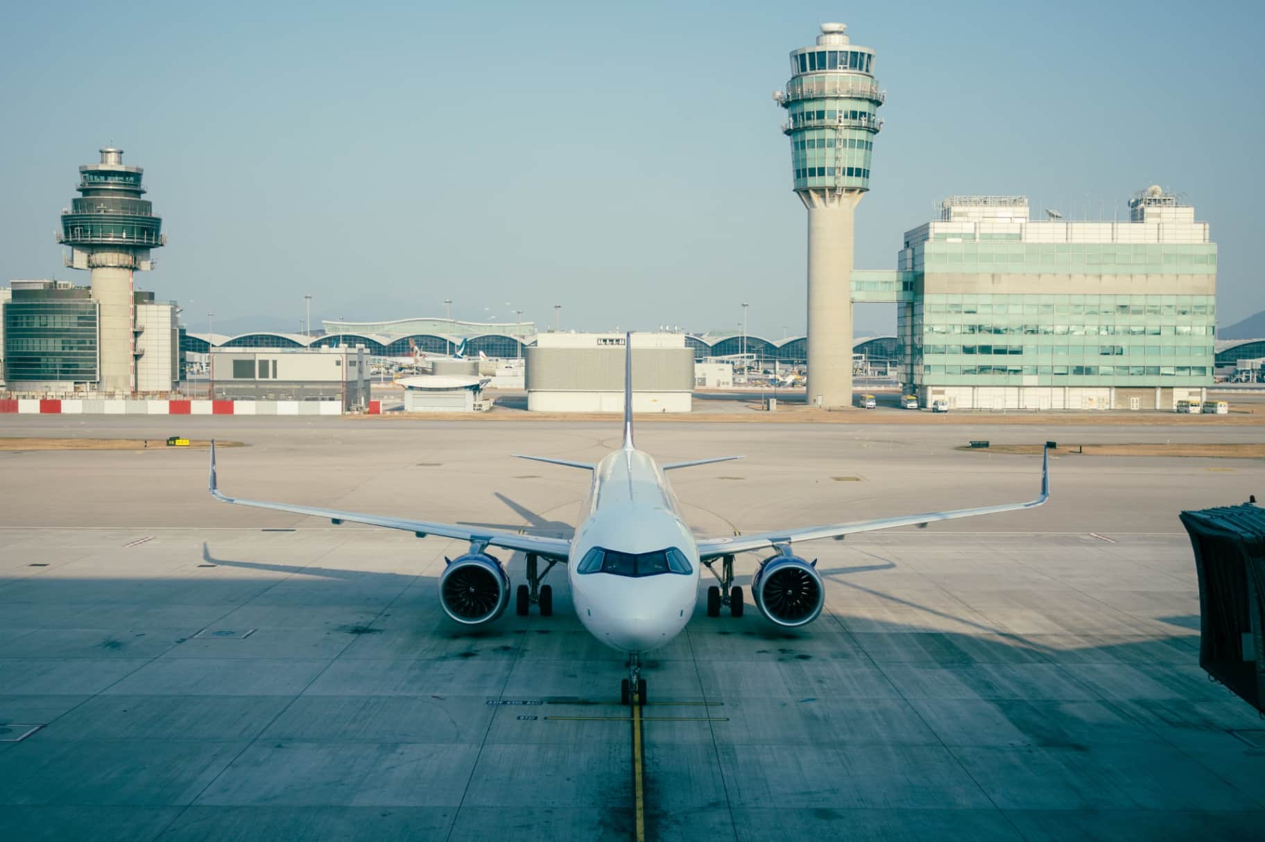 Front View of Passenger Airplane on Airport Tarmac with Control Towers